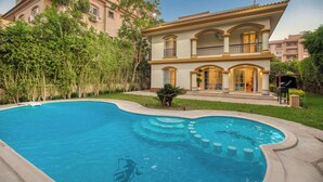 A large, two-story house with a swimming pool in the backyard. - Host Prime Paradise Villa At Rehab City (New Cairo)