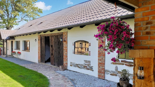 A traditional house with a tiled roof, a stone foundation, and a wooden door. - 3 bedroom nice apartment in Huta Gorna (Huta Gorna)