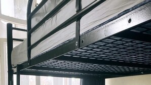 A bunk bed with a window, a metal railing, and a white mattress. - Bell House Hostel (London)