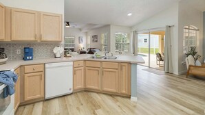 Una cocina moderna con armarios de madera, lavavajillas y una isla grande.