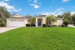 A single-story house with a garage, a front door, and a well-maintained lawn.
