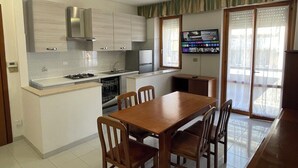 A modern kitchen with a dining area, a built-in oven, and a large window with blinds. - La Vedetta Holiday Home, spacious accommodation with sea view terrace (Termoli)