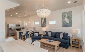 A modern living room with a sofa, coffee table, and dining area.