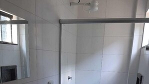A bathroom with a sink, toilet, and glass shower enclosure.