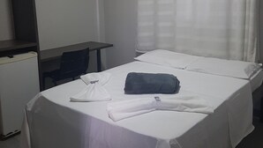 Ein Hotelzimmer mit Bett, Schreibtisch, Stuhl und Klimaanlage.