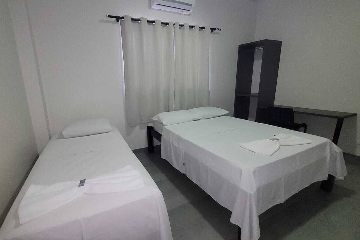 A room with two single beds, a desk, and a wardrobe.