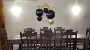 A dining area with a rectangular table surrounded by six wooden chairs.