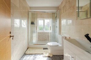 Une salle de bain moderne avec une douche à parois de verre, des toilettes et un lavabo.