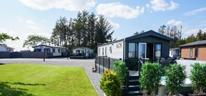 A row of mobile homes with a grassy area in the foreground.