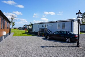 A residential area with a house, a car, and a street lamp. - Lodge No 83 | Hot Tub | Stewart's Resort Cameron (Cameron)