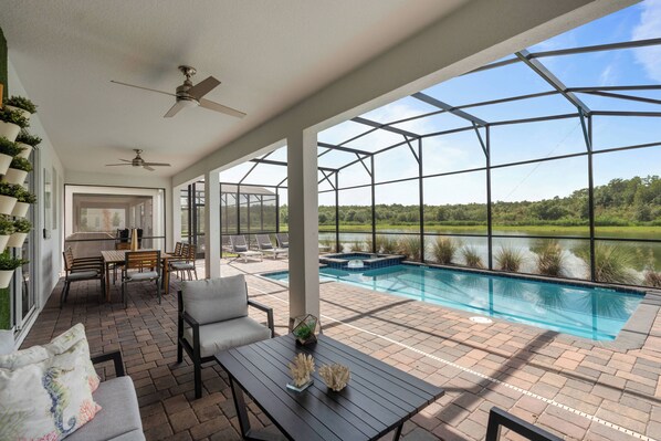 Un espacio al aire libre cubierto con piscina, asientos y vistas al exterior.