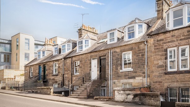 A row of stone townhouses with uniform architecture, featuring small front gardens and a clear street in front. - Kinness Place (No 6) (St Andrews)