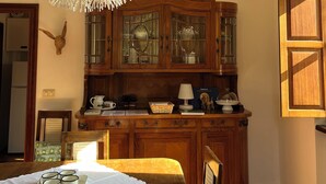 A kitchen with wooden cabinets, a chandelier, and a dining table set with cups. - Cozy apartment in country home a few km from Arezzo (Giovi-Ponte Alla Chiassa)