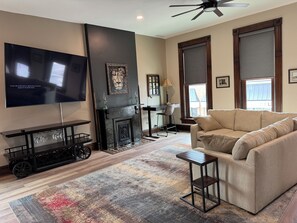 A modern living room with a flat-screen TV, a fireplace, a sofa, and a coffee table.