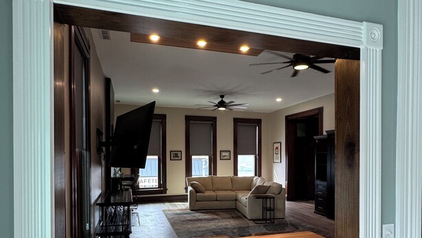 A modern living room with a wooden dining table, a sofa, and a ceiling fan. - Stadium Stay #4  The Presidents Suite.  Free Parking.  (Indianapolis)