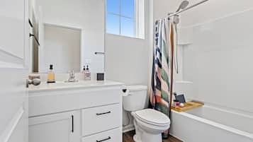 Une salle de bain moderne équipée de toilettes, d’un lavabo et d’une douche.