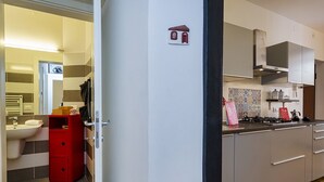 Een moderne keuken met een gasfornuis, een spoelbak en een rode bergkast.