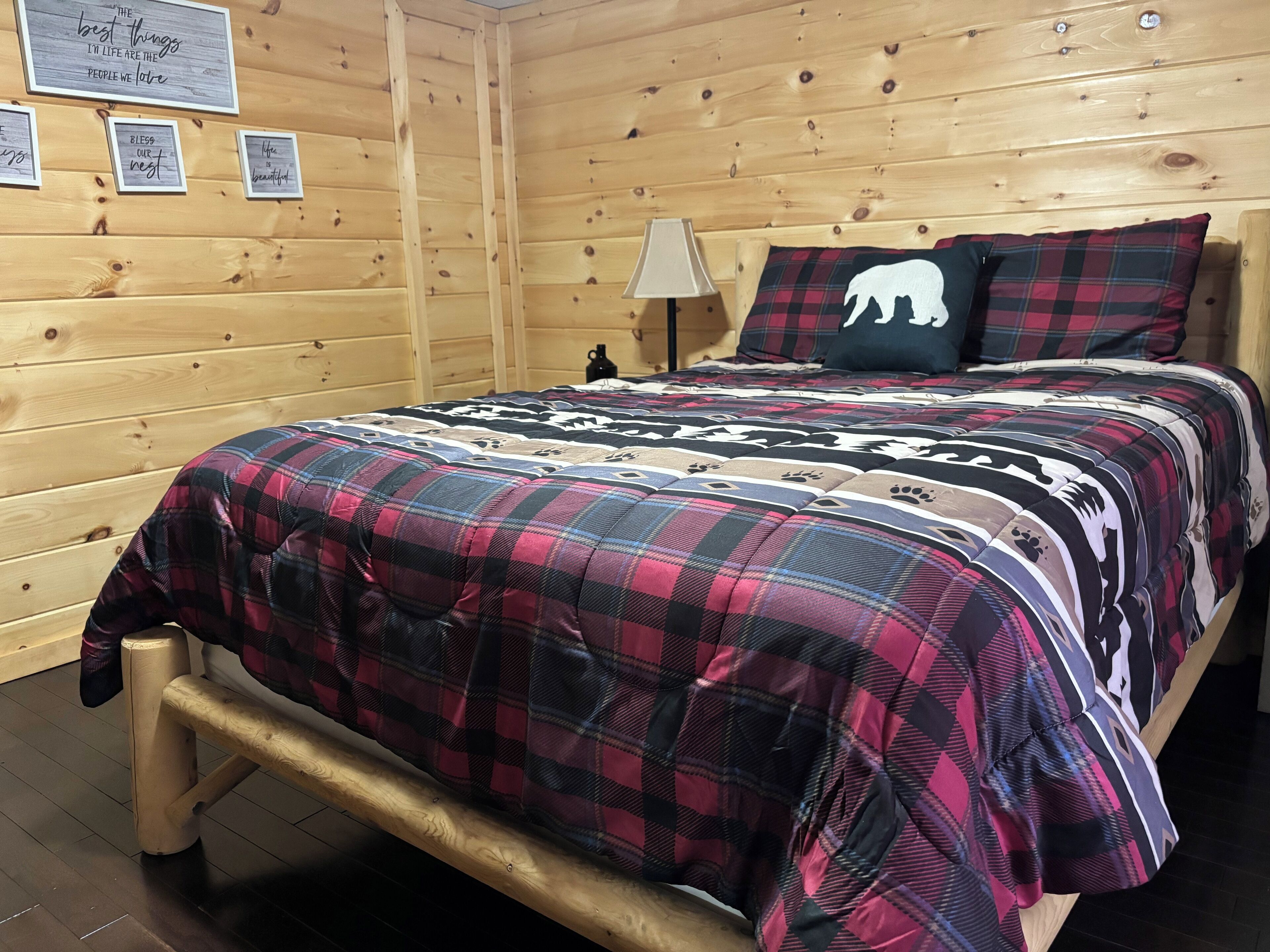 Une pièce de style cabane en bois, avec un lit, une lampe et des affiches motivantes accrochées au mur.