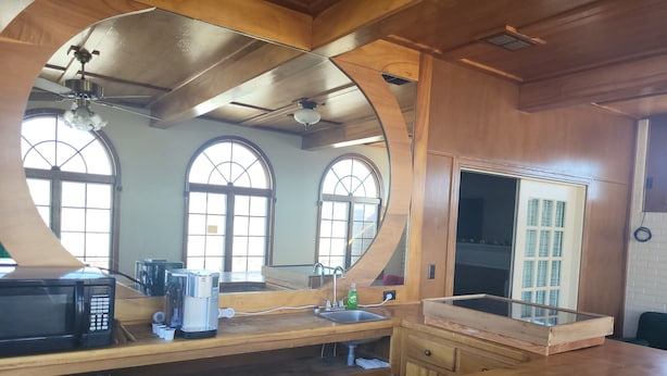 A kitchen with wooden cabinetry, a microwave, a coffee maker, and a sink. - Sunflower Room Apartment (Hobbs)