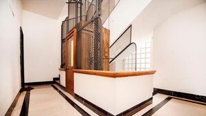 Un intérieur moderne avec un escalier, un banc en bois et un sol carrelé.
