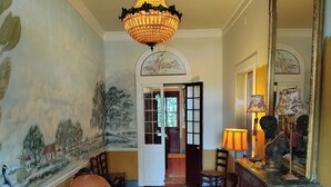A room with a chandelier, wooden furniture, a large mirror, and a mural on the wall. - Lafleur Guest House  (Washington)