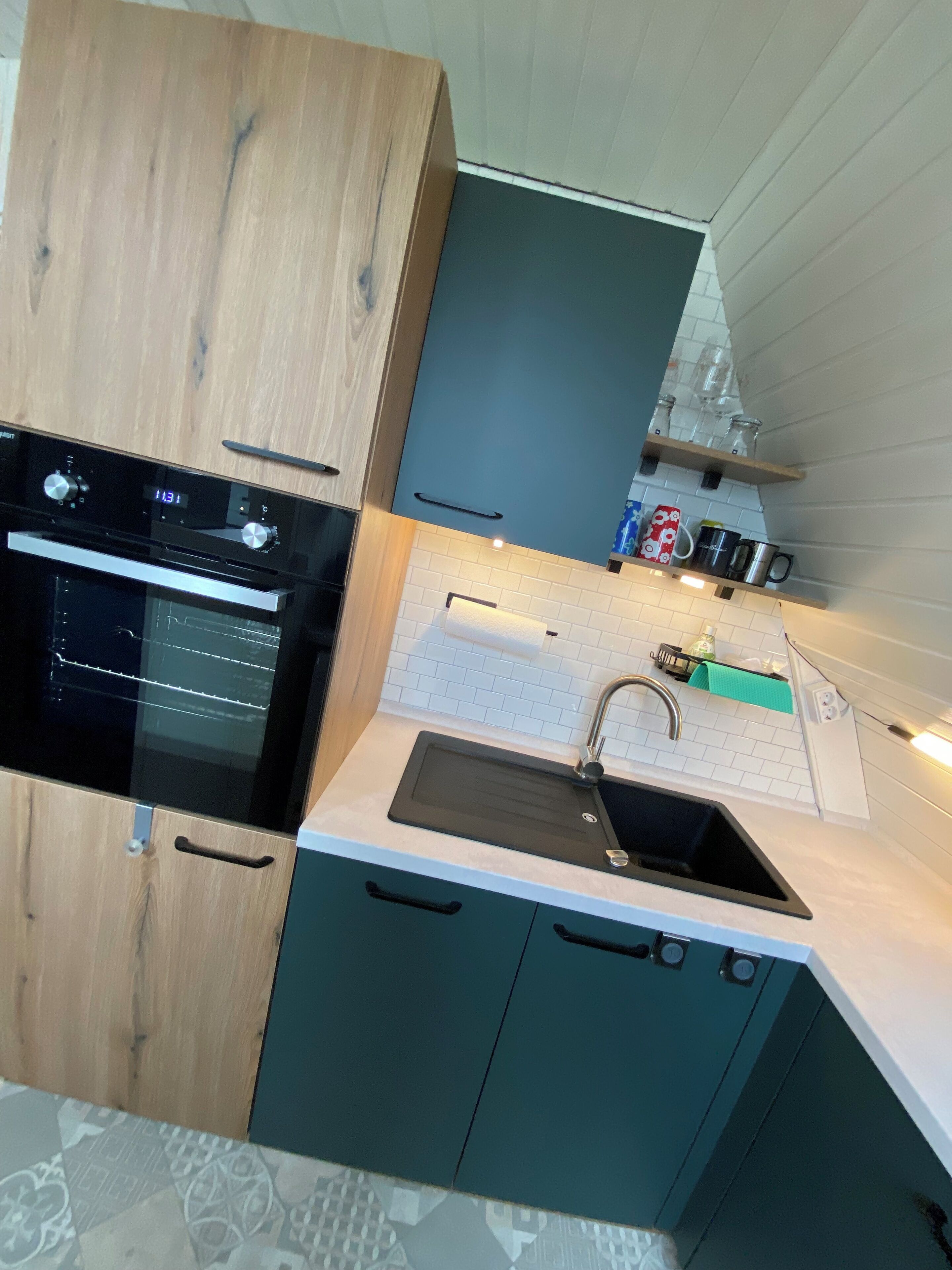 A modern kitchen with a built-in oven, a sink, and a countertop.