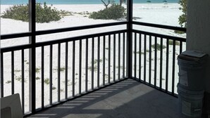 A balcony with a view of a beach and ocean. - Beachfront Sanibel Escape – Steps to Sand & Sunset Views (Sanibel)