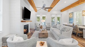 Un salón amplio con chimenea, asientos cómodos y televisor.