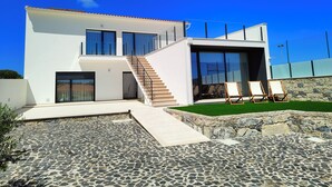 A modern two-story house with a stone patio, a staircase, and a pool area with lounge chairs. - Casa de Lazer da Chã (Alqueidão da Serra)