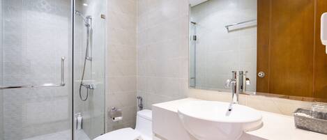 A modern bathroom with a glass-enclosed shower, a white toilet, and a vanity with a sink.