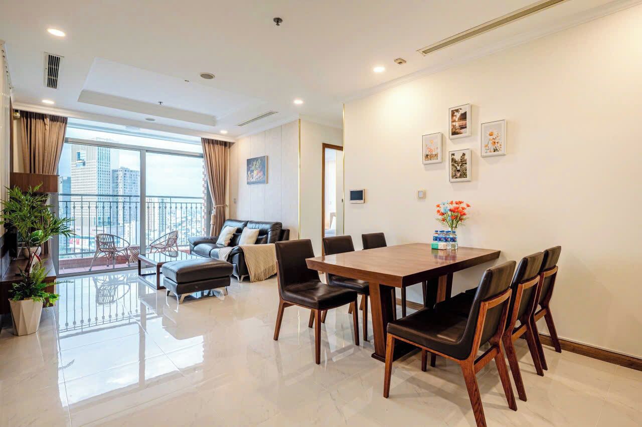 Un salon moderne avec un coin repas, de grandes fenêtres et un balcon.