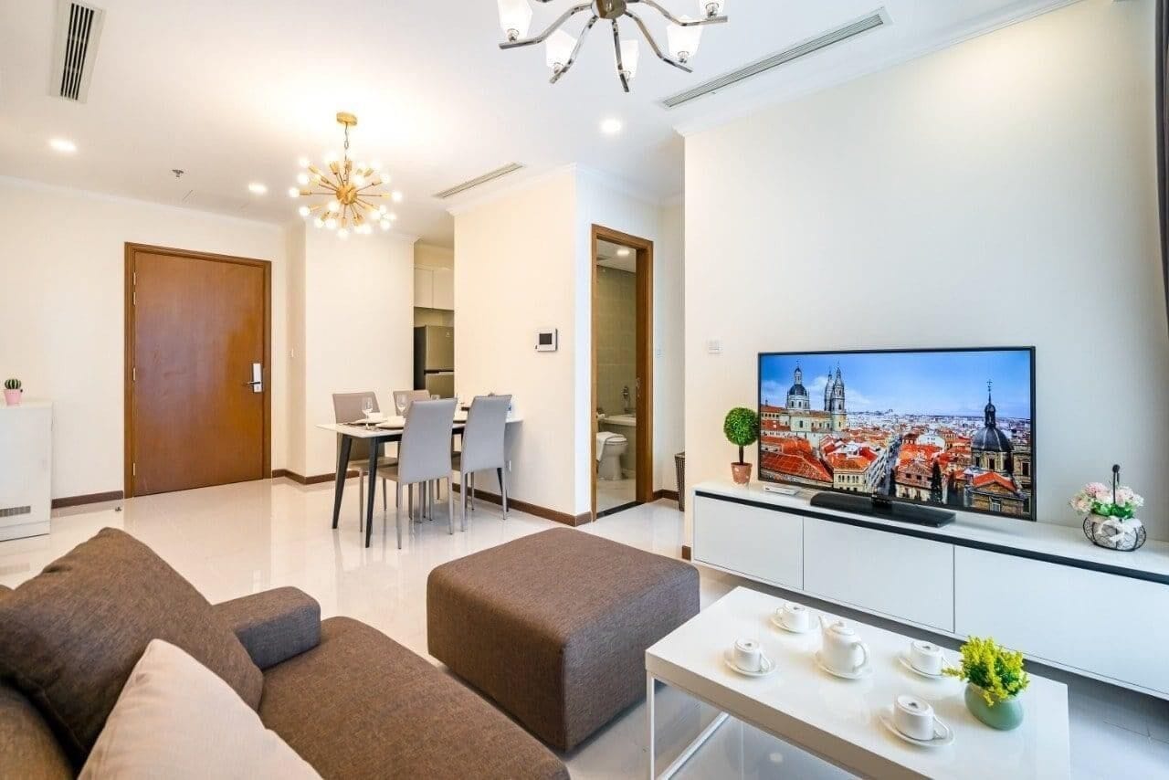 Un salon moderne doté d’un téléviseur à écran plat, d’un coin repas et d’une kitchenette.