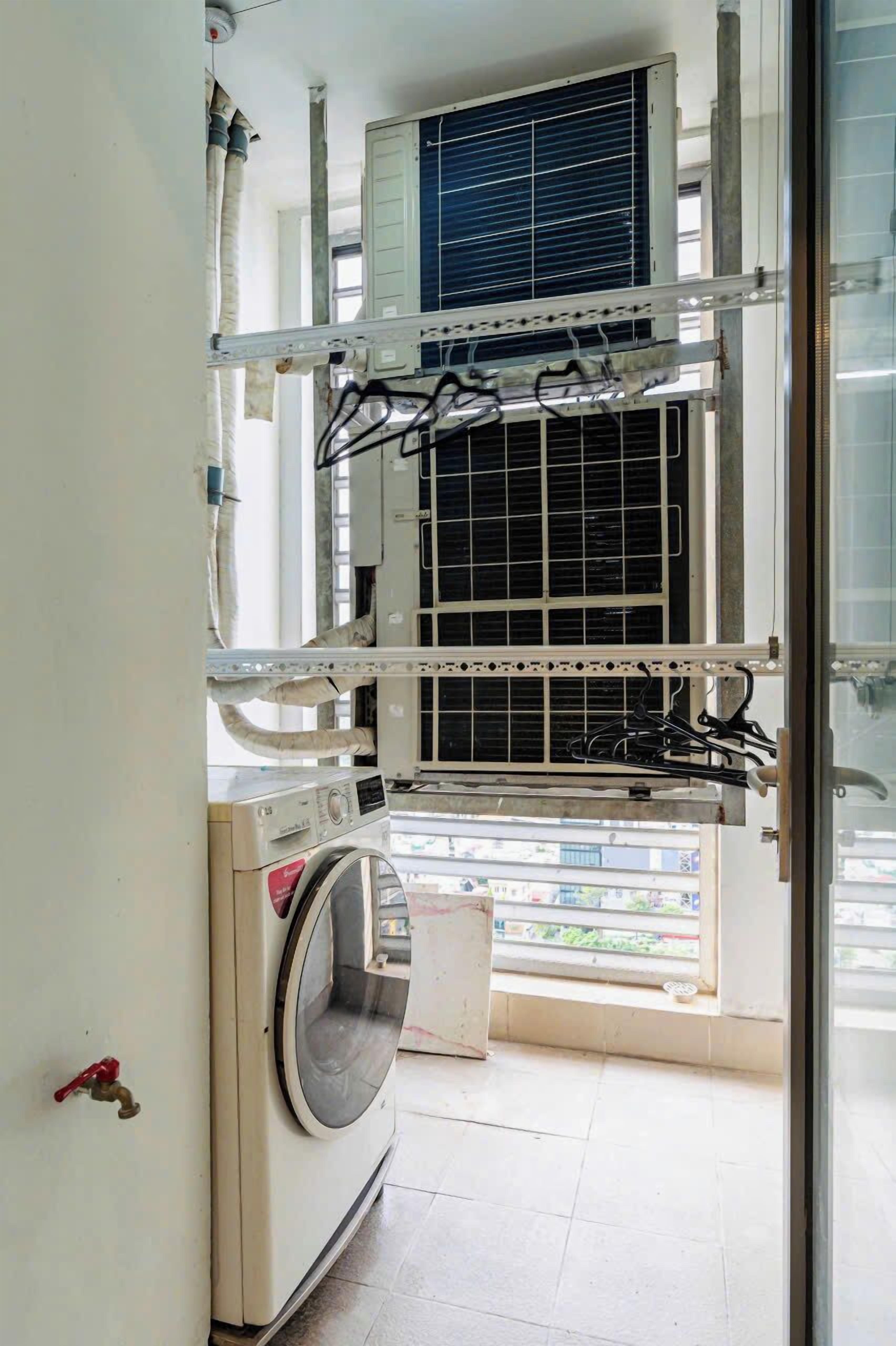 A laundry room with a washing machine, a dryer, and an air conditioning unit.