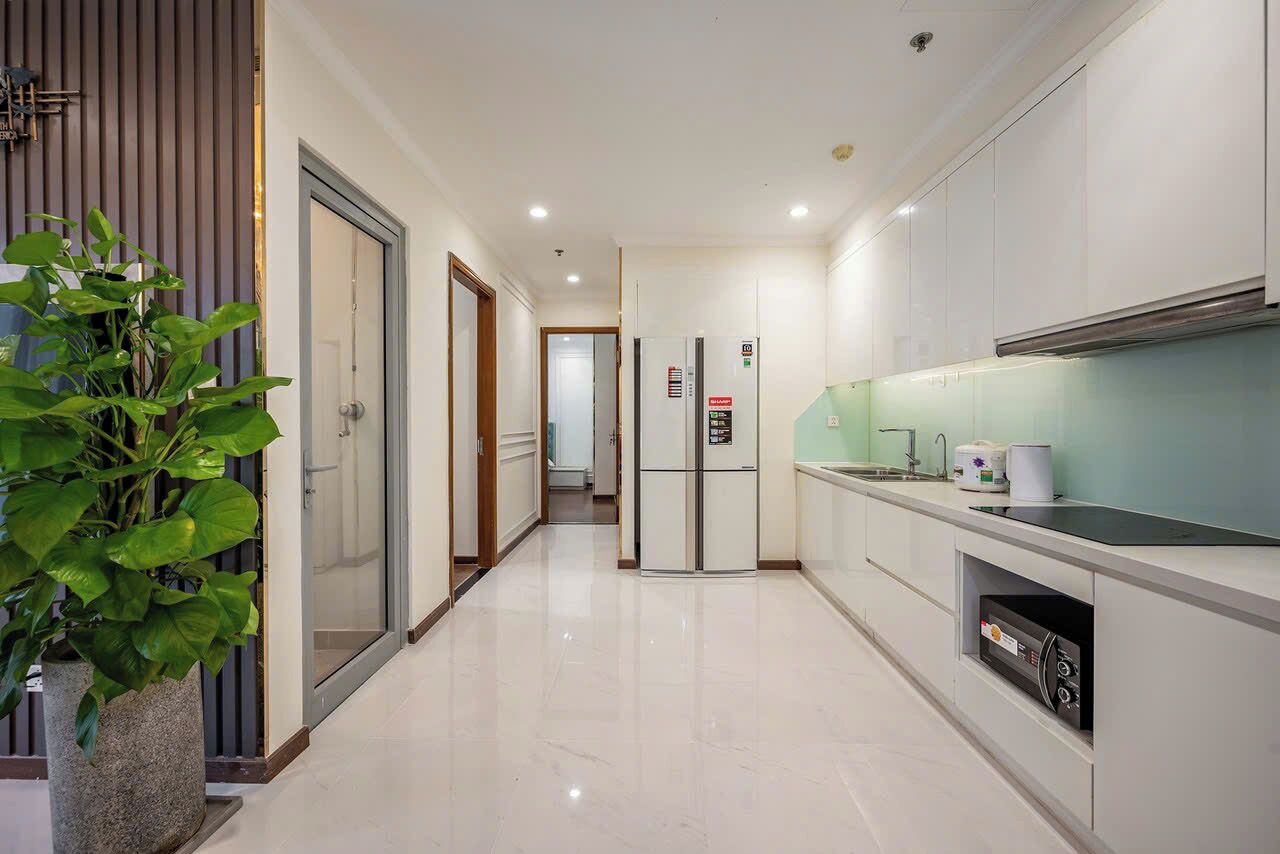 A modern kitchen with a refrigerator, microwave, and sink.
