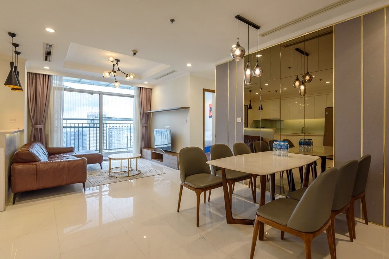 Una sala de estar moderna con un sofá, una mesa redonda de centro y un comedor con mesa y sillas.