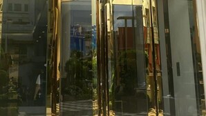 A building entrance with a checkered floor, large glass doors, and a sign above the doors. - Terra Royal Apartment (Ho Chi Minh City)