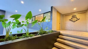 Un escalier moderne agrémenté d’un jardinier où sont plantées différentes espèces végétales.