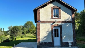 A small, single-story building with a brick facade and a white door, labeled with the number 57. - L'escale de Saint Martin (Saint-Martin-de-Mailloc)