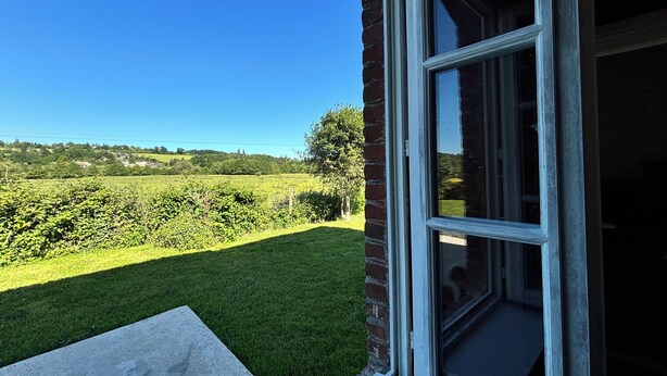 A view from a window overlooking a green field and distant hills. - L'escale de Saint Martin (Saint-Martin-de-Mailloc)