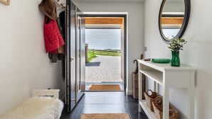A hallway with a door leading to a gravel path and a view of a green landscape. - 3 Bed in Hartland (oc-w29797) (Hartland)