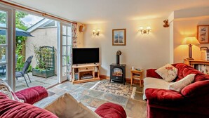 A cozy living room with a television, a fireplace, and a red sofa.