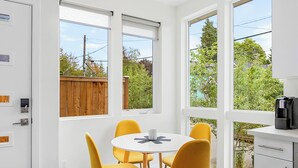 Una cocina moderna con zona de comedor, ventanas amplias y vistas al exterior.
