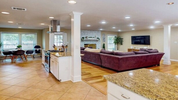 A spacious living area with a kitchen, dining area, and a large sofa. - Charming 3-bed, 2- bath house with open concept living and sunroom in Savannah (Savannah)