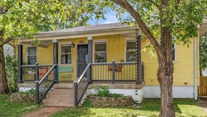 A yellow house with a porch, a black door, and a number 402 sign. - Charming 2 BR house in Old Hickory Village, a short walk from the lake road  (Nashville)