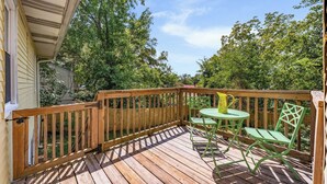 A wooden deck with a table and chairs, surrounded by trees. - Charming 2 BR house in Old Hickory Village, a short walk from the lake road  (Nashville)