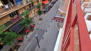 Ein mehrstöckiges Wohngebäude mit Balkonen, eine Straße davor und ein Schild mit der Aufschrift 'Pens El Cielo'.