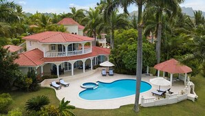 A large house with a swimming pool, surrounded by palm trees and a well-maintained lawn. - Lifestyles (Puerto Plata)