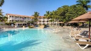 A swimming pool with lounge chairs and palm trees. - Lifestyles (Puerto Plata)