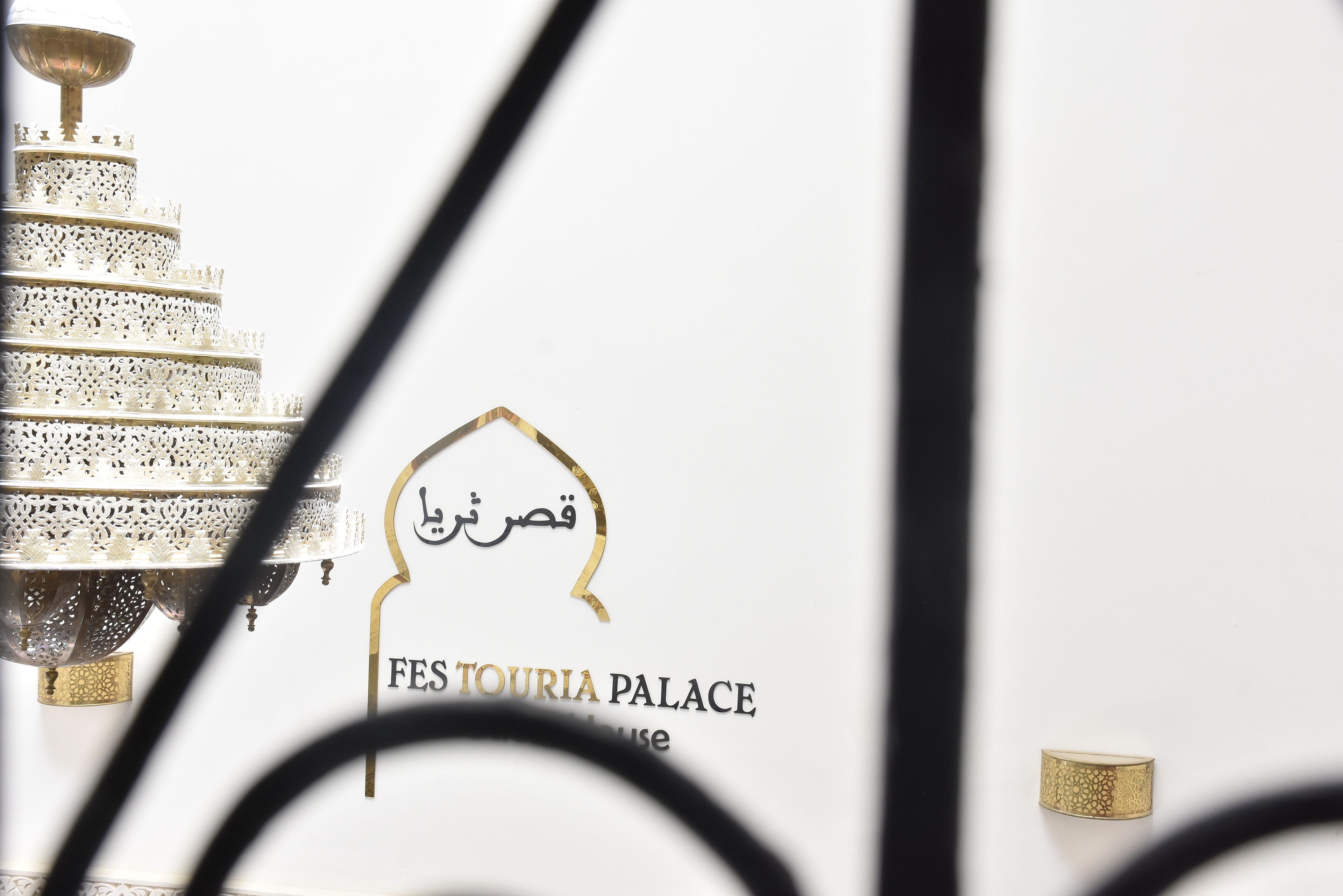 Un letrero para FEST TOURIA PALACE con escritura árabe y texto en inglés.