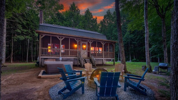 A cabin with a deck, outdoor seating, and a fire pit. - Lake front, hot tub, kayak, paddle board, Dogs, Mount Desert Island, Bar Harbor! (Mariaville)